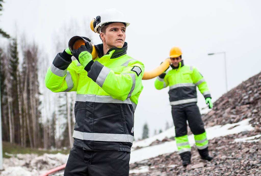 Profissionais com roupa de trabalho de inverno numa obra