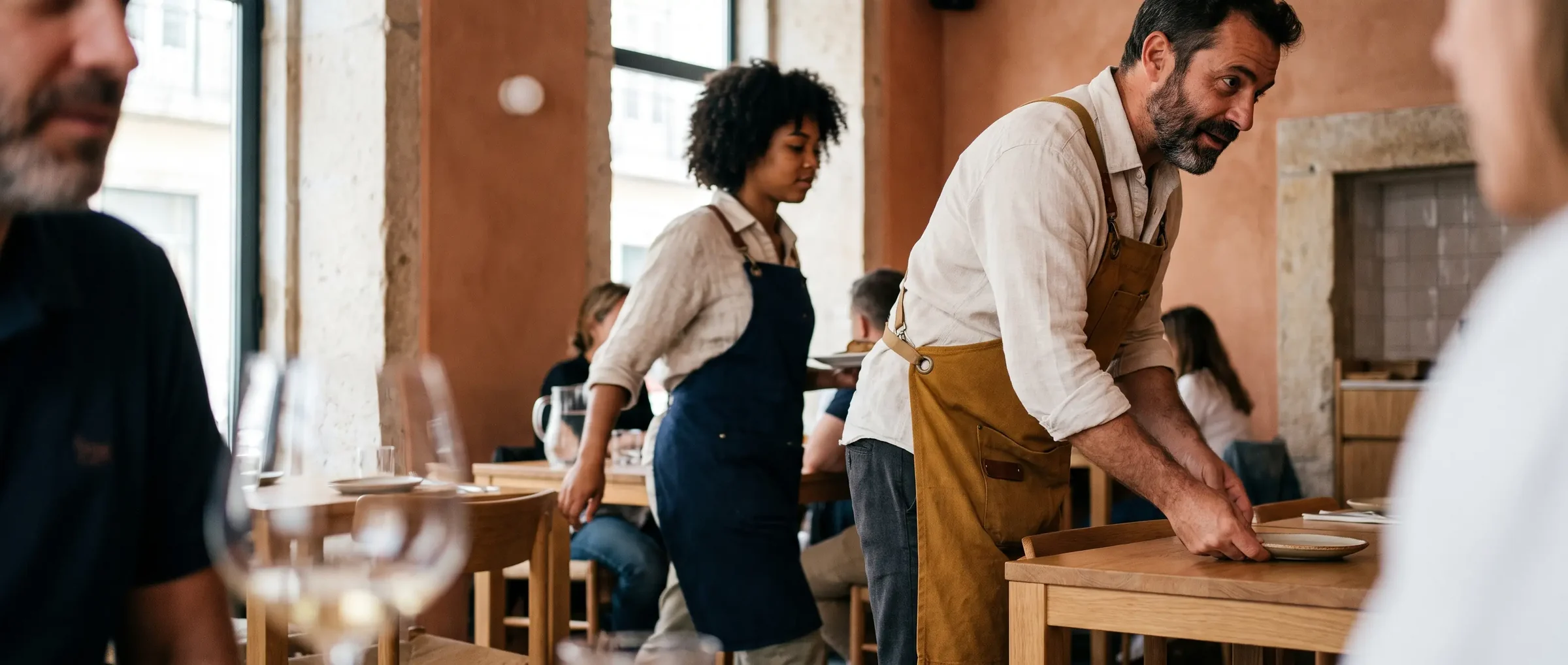 Profissional de restauração a preparar uma mesa com avental