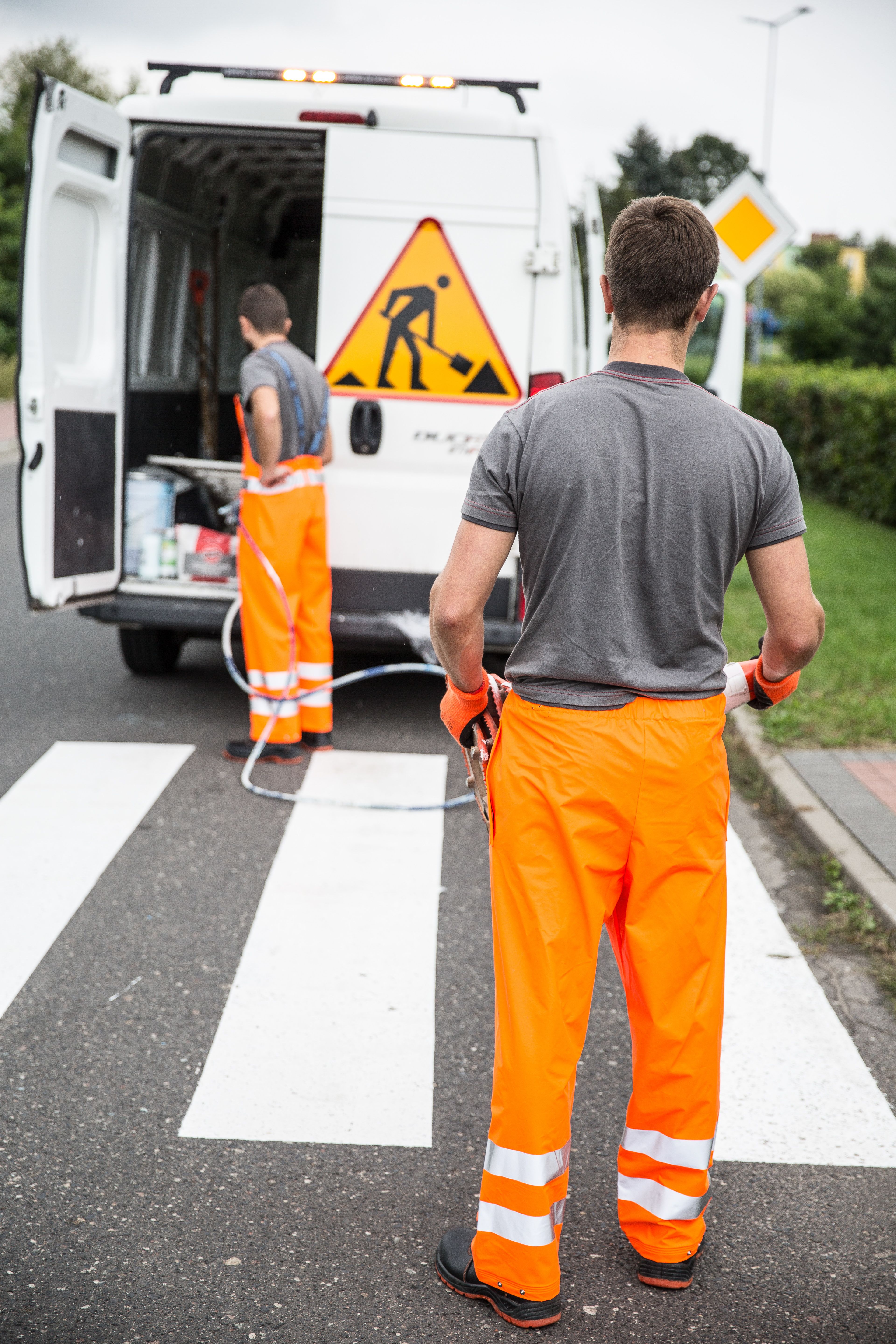 Profissionais com vestuário laboral de alta visibilidade numa equipa de manutenção rodoviária